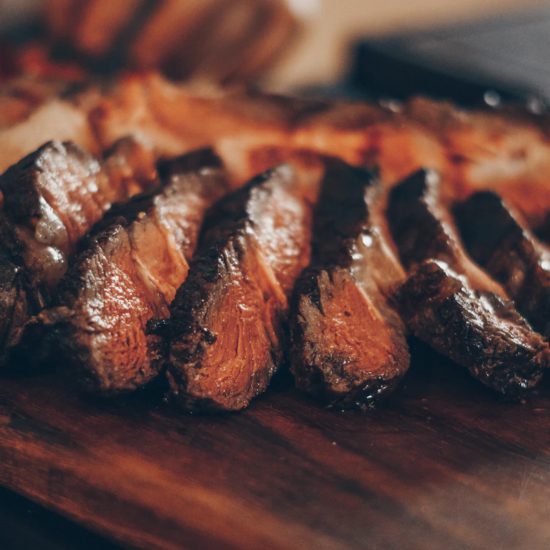 Carne grelhada fatiada numa tábua de madeira